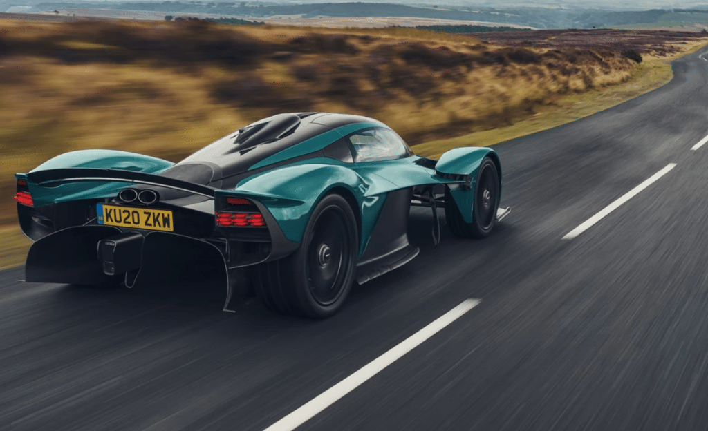 Green Aston Martin Valkyrie driving on a road