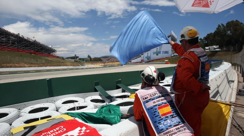 Marshal waving a blue flag at trackside
