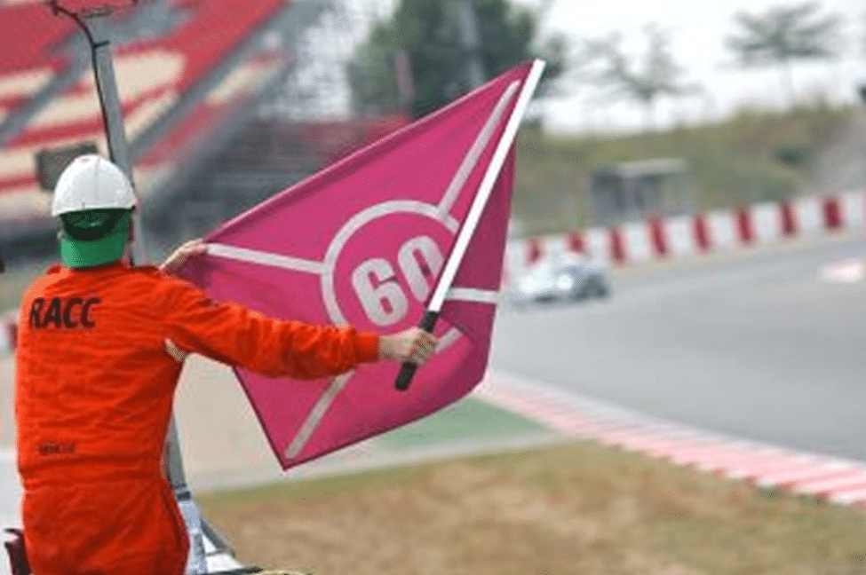 Marshal holding a purple Code 60 flag at trackside