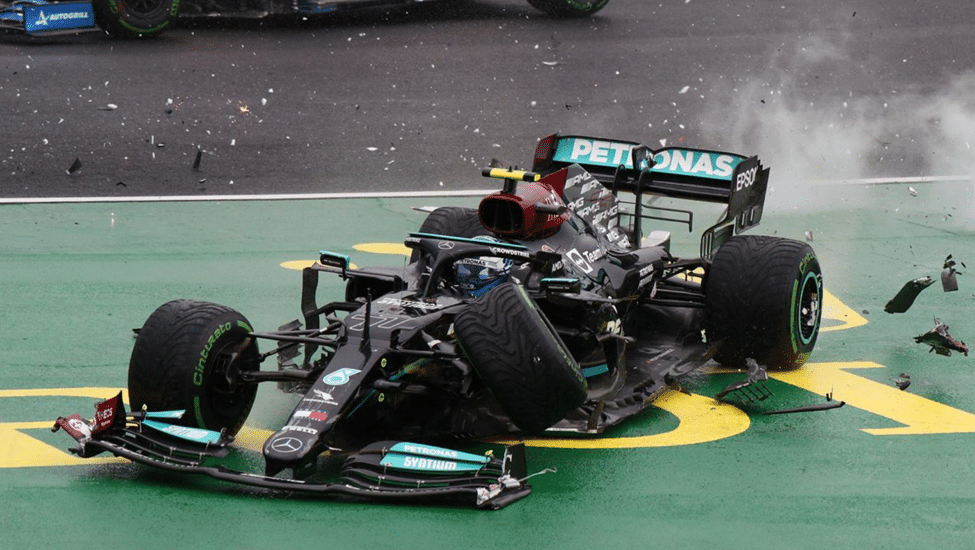 Mercedes F1 car with a burst tyre and debris scattered on track