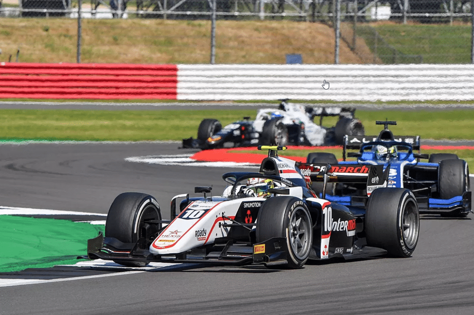 Haas F2 car leading a pack of single-seaters at Silverstone