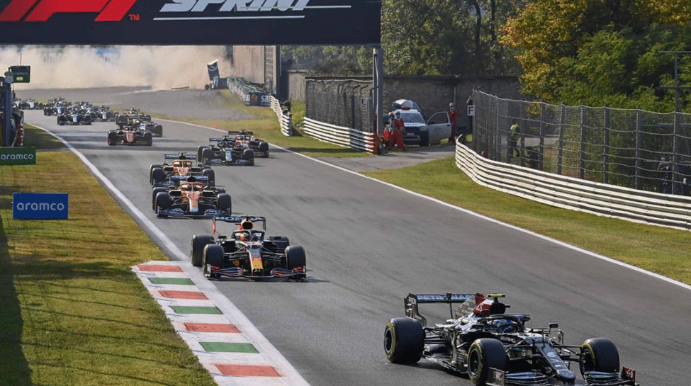 F1 cars racing at Monza with a car spinning in the background