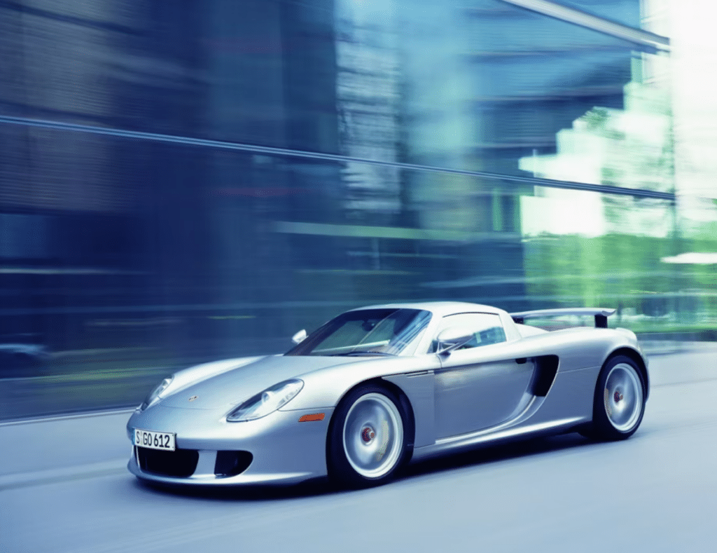 Silver Porsche Carrera GT in motion on a road