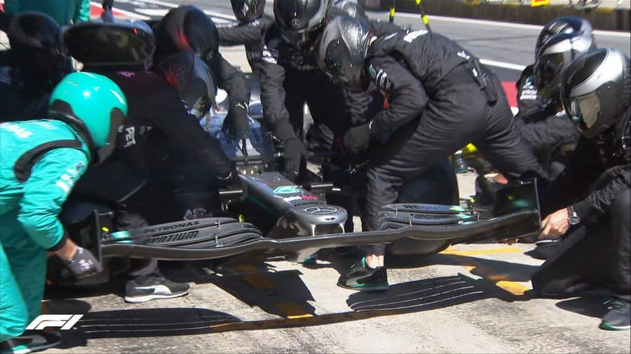 Mercedes F1 wing men adjusting front wing during pit stop